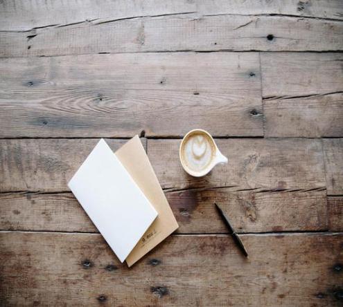 Notitieblok en koffie op een houten tafel