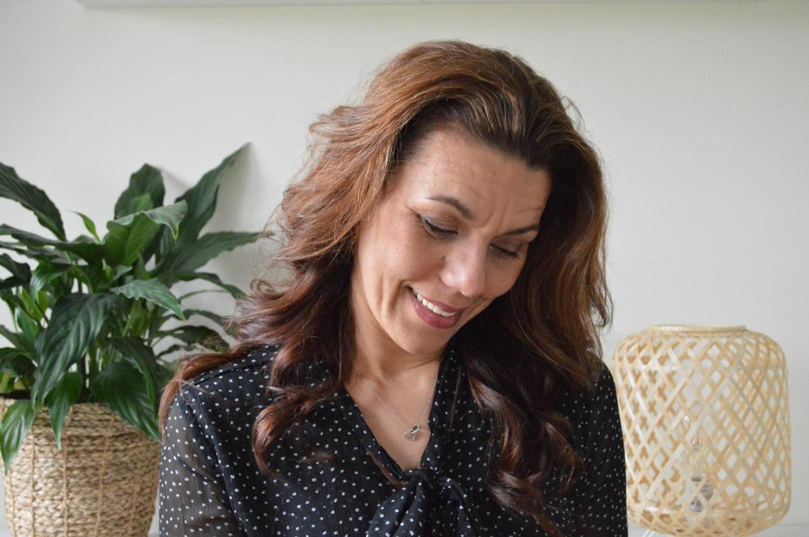 Stefanie Terhürne naast een plant, lachend naar beneden kijkend
